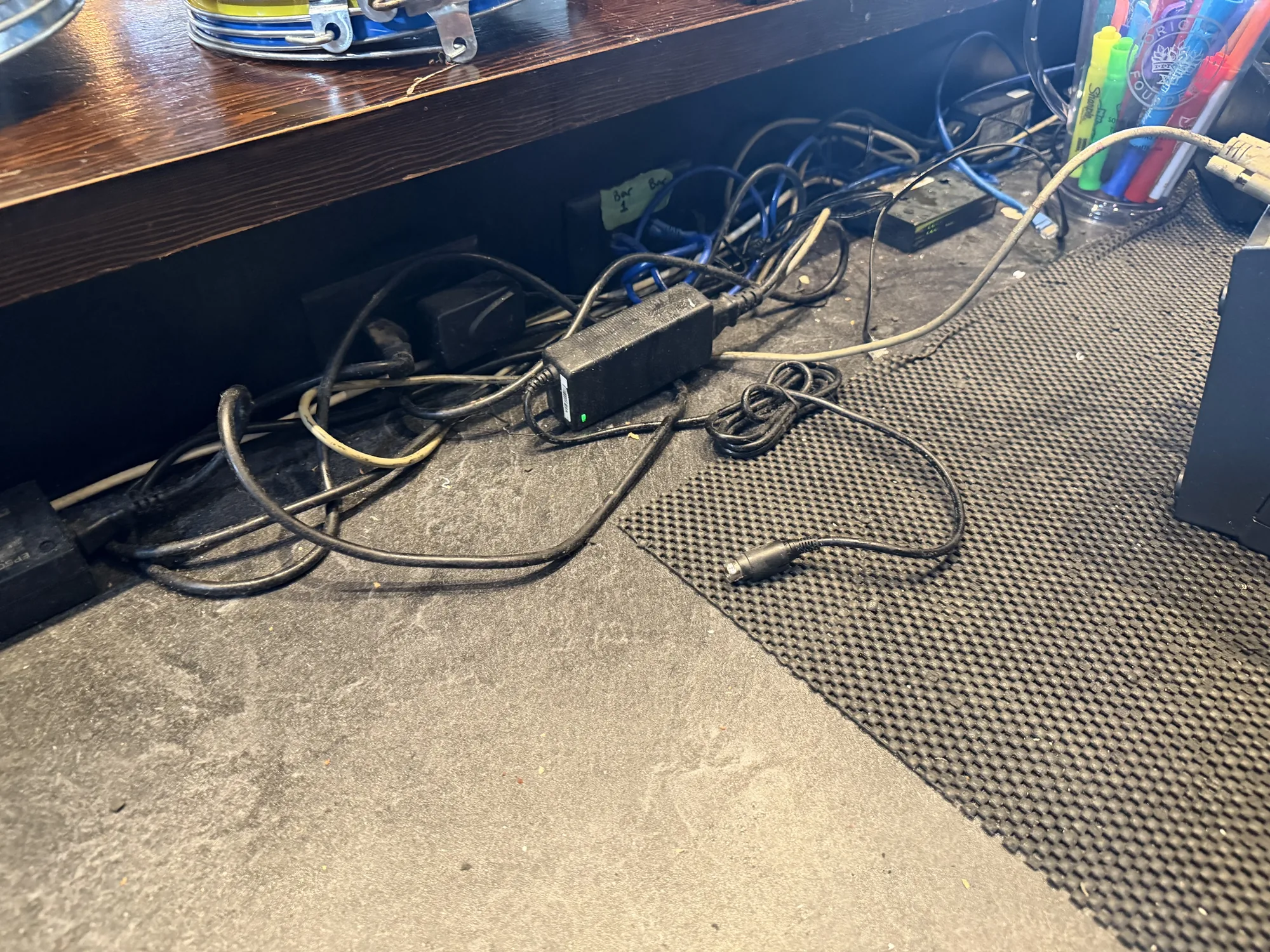 Tangled power and data cables under the counter before cleanup